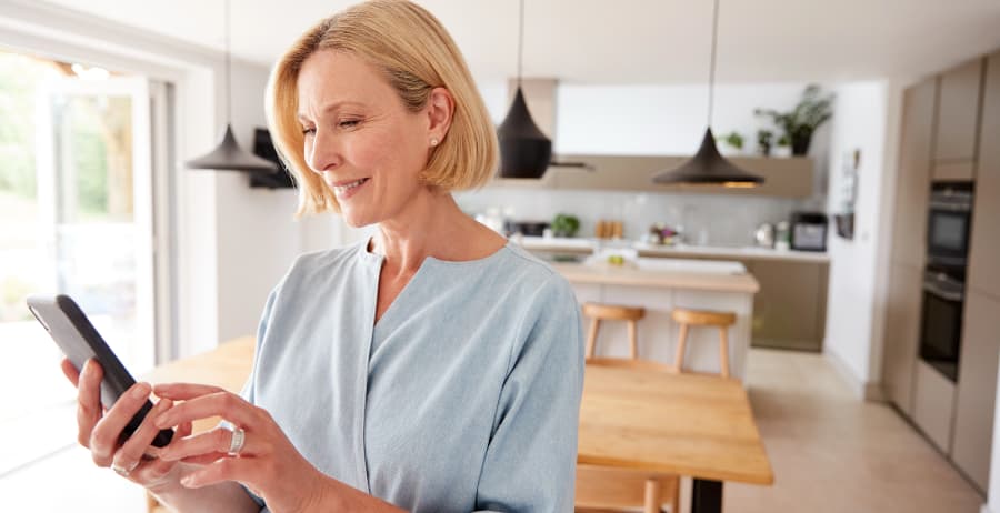 Homeowner holding a cell phone in a modern home